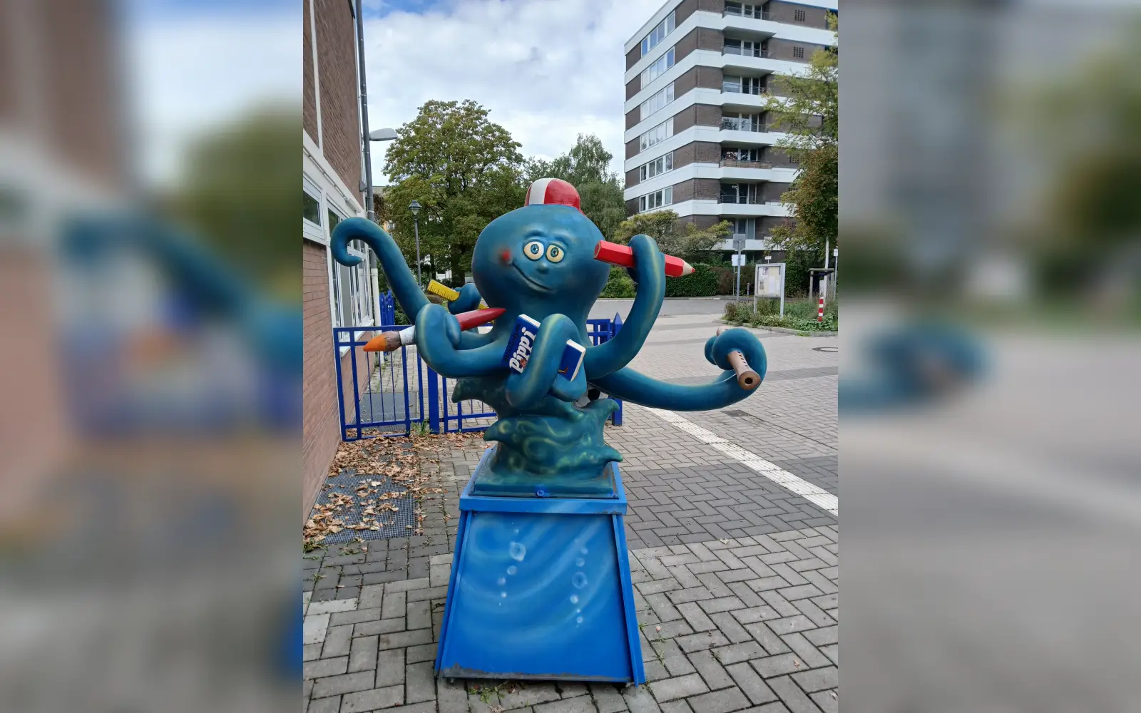 Kinder aus zahlreichen Ländern lernen an der Gemeinschaftsgrundschule Lörick gemeinsam. An der Schule steht eine bemalte Krakenskulptur mit Buntstiften, einer Blockflöte und einem Pippi-Langstrumpf-Buch in den Armen. Foto: kh